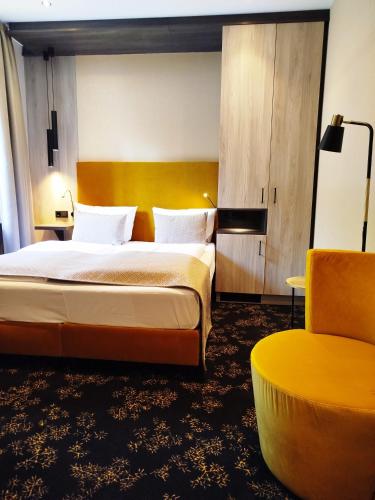 a hotel room with a bed and a chair at Akzent Waldhotel Rheingau in Geisenheim