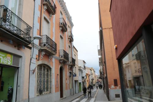 a group of people walking down a street with buildings at Hostal Plaja i Pati de Can Plaja in Palafrugell