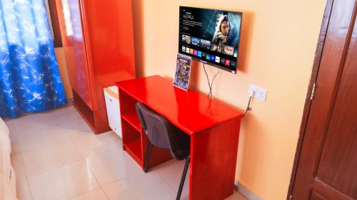 a red desk with a television on top of it at Durban Hotel in Dar es Salaam