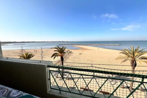 une vue sur une plage avec des palmiers et l'océan dans l'établissement La Croix du Sud 4 - Appartement en duplex Vue Mer 1ère ligne avec terrasse, au Grau-du-Roi