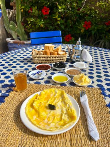 a table with a plate of food and bread on it at Tasra Surf Paradise, Imsouane in Imsouane