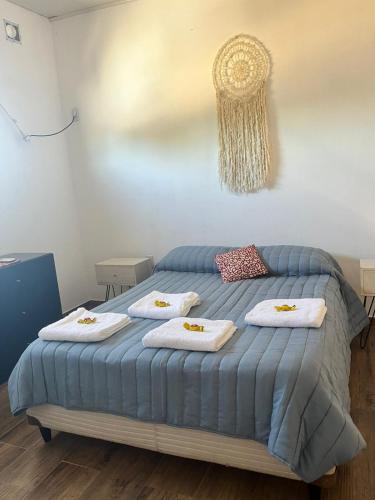a bedroom with a blue bed with towels on it at Shanti Loft in Concepción del Uruguay