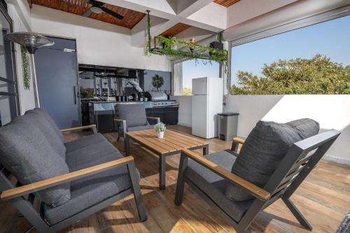 a living room with chairs and a table and a kitchen at הפנטהאוז של תל אביב - דירות סטודיו מהממות ופנטהאוז משגע עם ג'קוזי פרטי! in Tel Aviv