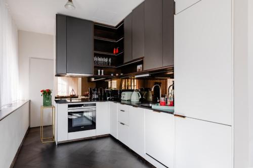 a kitchen with black cabinets and white appliances at JOKER! Off Oxford St! 3Bed 3Bath LuXXe Hideaway for Stylish Families and Couples in London