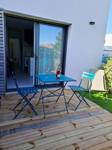 une table bleue et deux chaises sur une terrasse dans l'établissement Platin, à Saint-Palais-sur-Mer