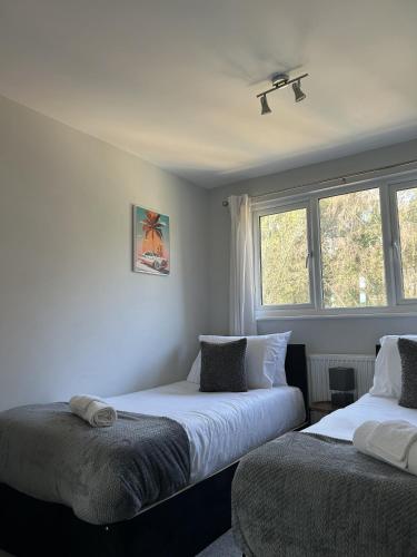 a bedroom with two beds and a window at 3 Bed House Close to Gatwick in Crawley