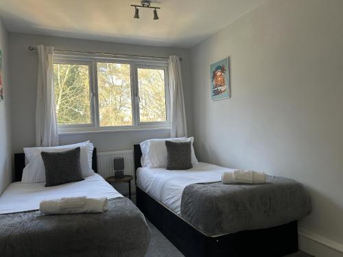a bedroom with two beds and a window at 3 Bed House Close to Gatwick in Crawley