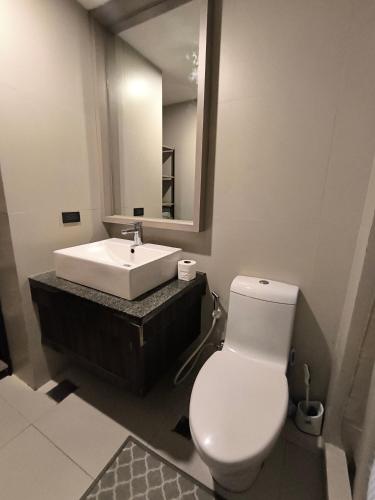 a bathroom with a white toilet and a sink at The Serena Suite in Manila