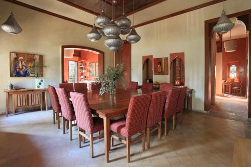 a dining room with a wooden table and chairs at Villa Layyine avec personnel, piscine, spa et sports in Marrakech