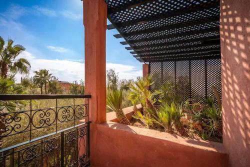 a balcony of a house with a fence and plants at Villa Layyine avec personnel, piscine, spa et sports in Marrakech