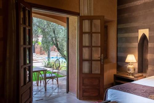 a bedroom with a door leading to a patio at Villa Layyine avec personnel, piscine, spa et sports in Marrakech