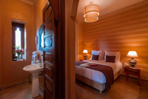a bedroom with a bed and a sink in it at Villa Layyine avec personnel, piscine, spa et sports in Marrakech