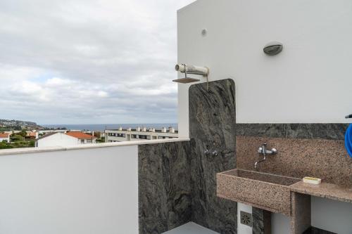 a bathroom with a sink and a view of the ocean at Serra & Mar in Vila Franca do Campo