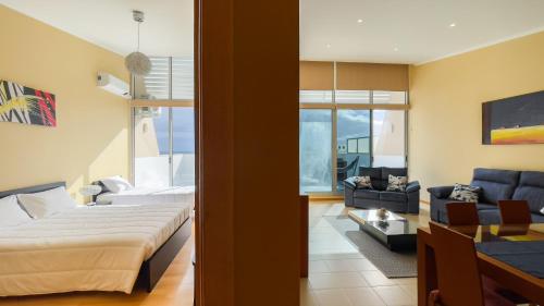 a bedroom with a bed and a living room at Serra & Mar in Vila Franca do Campo