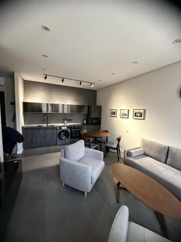 a living room with two couches and a kitchen at Bright home in Yerevan