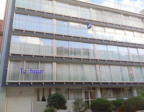 a building with a sign on the side of it at Viking Koksijde appartement 8 personen in Galopen