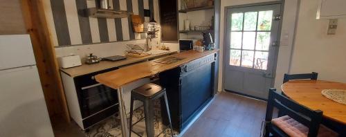 une cuisine avec un comptoir et une table à l'intérieur dans l'établissement Le Jas du Tilleul, à Villecroze