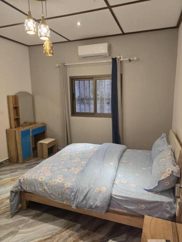 a bedroom with a bed with blue sheets and a window at cite blanche in Bangui