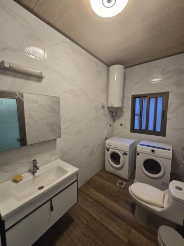 a bathroom with a sink and a washing machine at cite blanche in Bangui