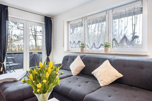 a living room with a couch and two windows at Moderne Unterkunft in Leutkirch in Leutkirch im Allgäu