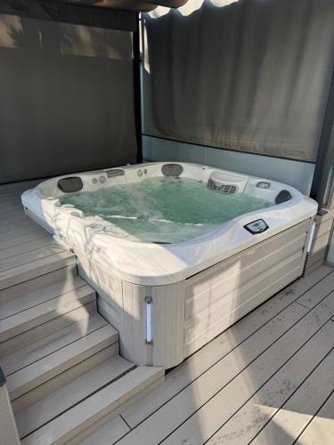 a jacuzzi tub sitting on a wooden floor at Arena Deluxe & Spa in Szeged