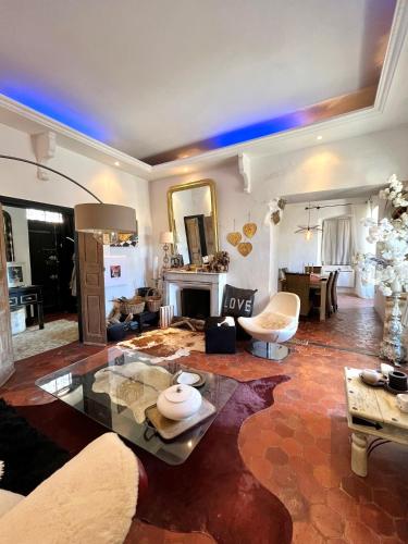 un grand salon avec une table et une cheminée dans l'établissement Superbe maison de charme vue mer, à Corbara