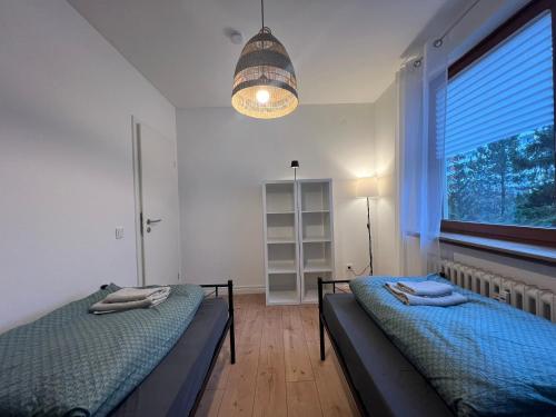 a bedroom with two beds and a large window at Wohnung Leverkusen I Garage I 4 Schlafzimmer in Leverkusen