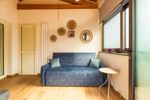 a blue couch in a living room with a window at Villa Graziella in Tremestieri Etneo