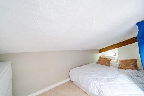 une petite chambre avec un lit dans un grenier dans l'établissement Cosy studio proche Gare de Nice, à Nice