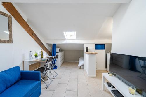 un salon avec un canapé bleu et une cuisine dans l'établissement Cosy studio proche Gare de Nice, à Nice