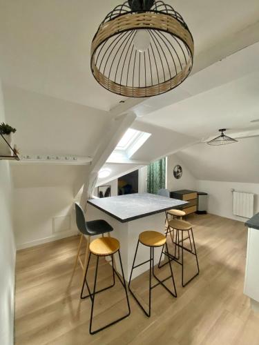 - une cuisine et une salle à manger avec une table et des tabourets dans l'établissement Belle appartement 4 chambres, à Reims