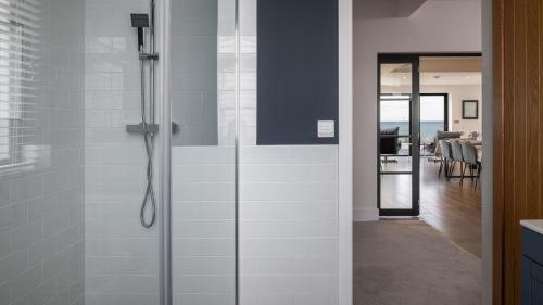 a shower with a glass door in a bathroom at 105 The Beach House in Penrhyn Bay