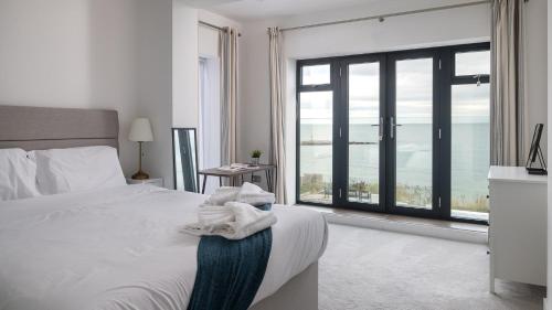 a bedroom with a bed with a view of the ocean at 105 The Beach House in Penrhyn Bay