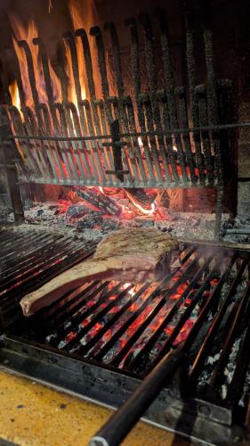 a grill with a bunch of meat and fire at Le Bataclan in Auron