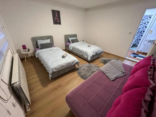 a room with three beds and a purple couch at Apartment Ramdedovic1 in Sarajevo