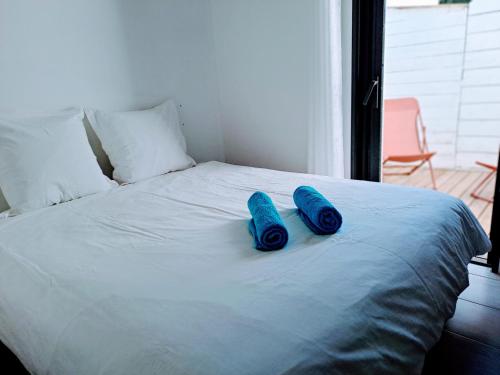 - deux chaussons bleus installés sur un lit blanc dans l'établissement Cordouan, à Saint-Palais-sur-Mer