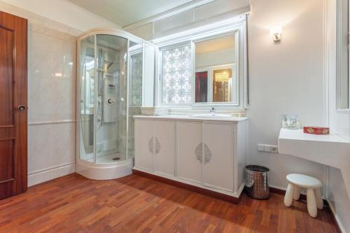 Un baño blanco con ducha y lavabo. en Villa Drago, en Castelldefels