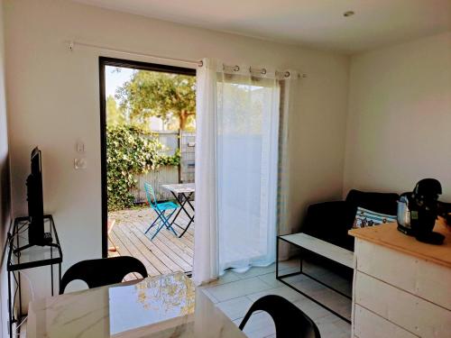 - un salon avec une porte s'ouvrant sur une terrasse dans l'établissement Cordouan, à Saint-Palais-sur-Mer