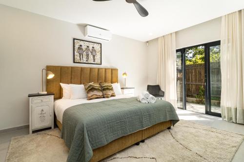 a bedroom with a large bed with a green blanket at The Royal Junction in Riebeek-Kasteel
