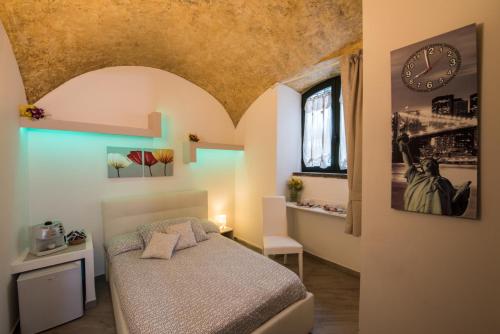 sypialnia z łóżkiem i zegarem na ścianie w obiekcie Petros Room Camere w mieście Salerno