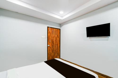 a room with a door and a tv on the wall at Super Collection O Malkajgiri in Hyderabad