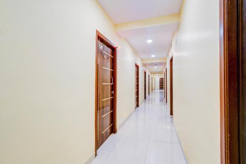 an empty hallway with wooden doors and white walls at Super Collection O Malkajgiri in Hyderabad