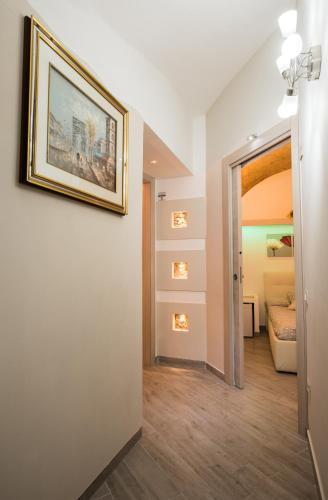 a hallway with a painting on the wall and a bedroom at Petros rooms&apartments in Salerno