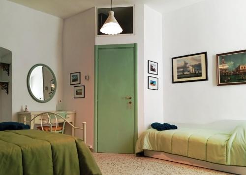 una camera da letto con due letti e una porta verde di Casa Antica Cibbun a Martina Franca