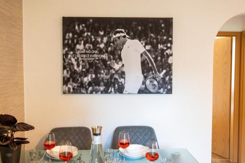 un tavolo con bicchieri da vino e una foto sul muro di Special ROGER F RABBIT 1 Apartment, Roche Towers, 10-STAR a Basilea