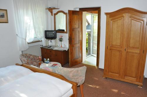 a bedroom with a bed and a tv and a door at Pension Johanna in Aßmannshausen