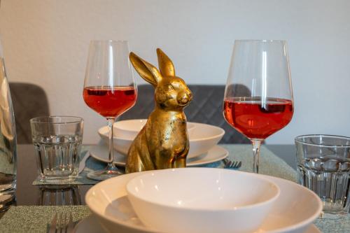 a table with glasses of wine and a statue of a rabbit at Special ROGER F RABBIT 2 Apartment, Roche Towers, 10-STAR in Basel