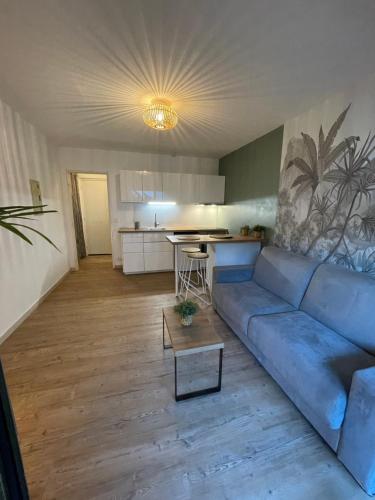 un salon avec un canapé bleu et une cuisine dans l'établissement Studio carré d’or Juan les Pins, à Antibes