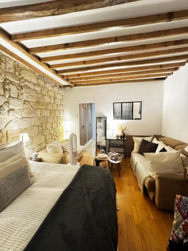 - un salon avec un lit et un mur en pierre dans l'établissement Beautiful stay in Paris, à Paris
