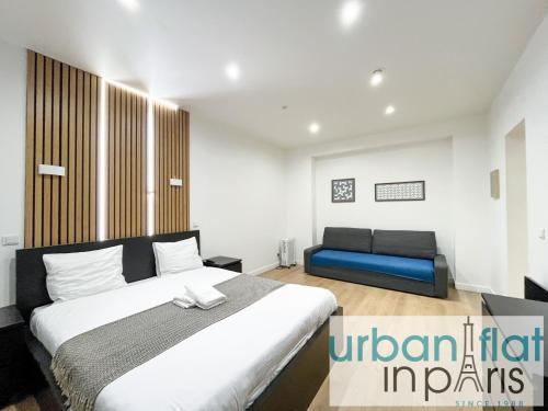 une chambre avec un grand lit et un canapé bleu dans l'établissement 52 - Urban Collection Grands Boulevards, à Paris